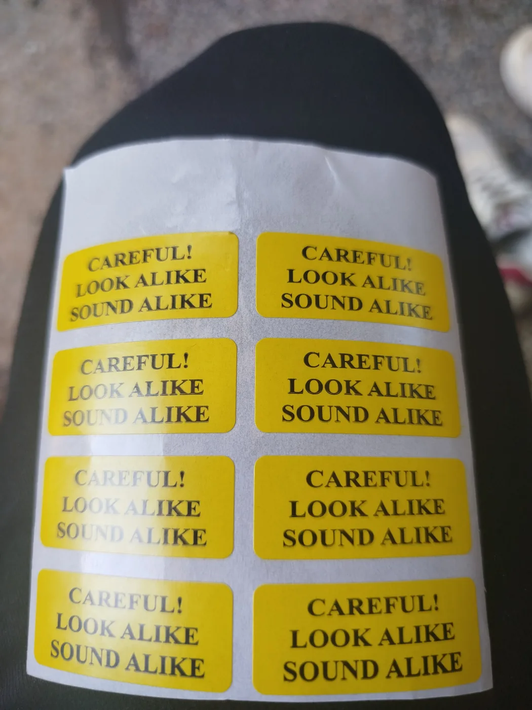 Warning labels applied to a curved surface, showing how the adhesive conforms