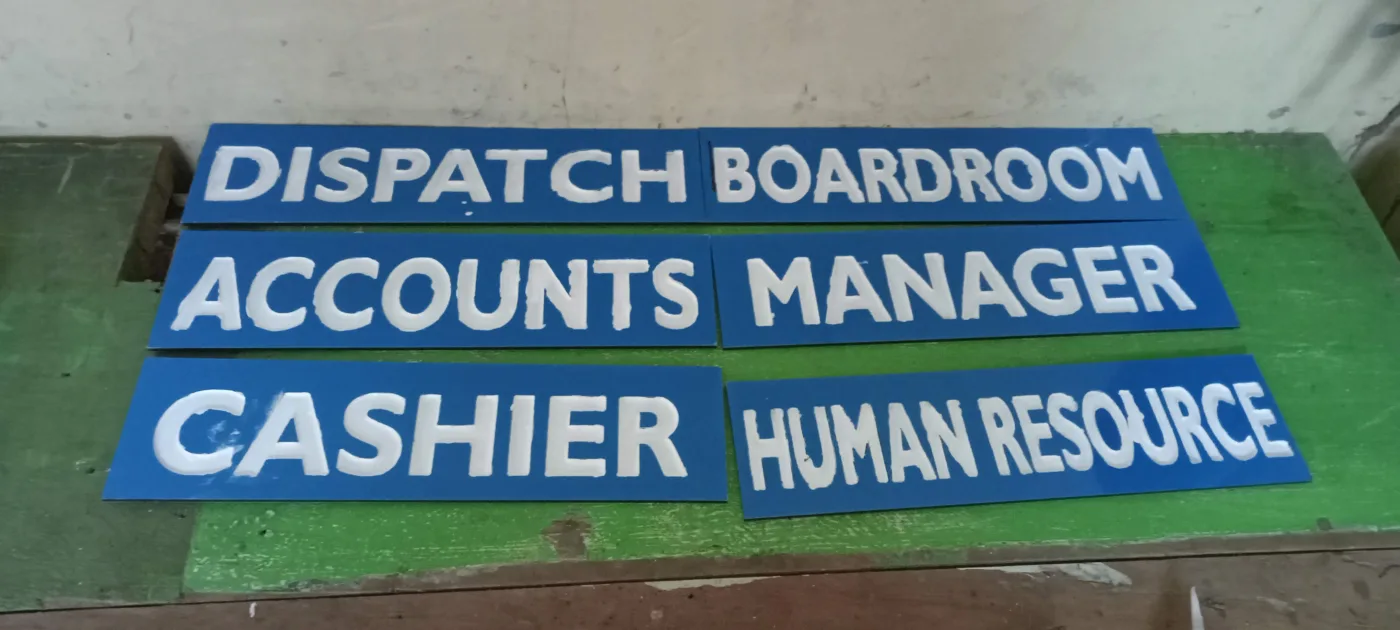 Raised acrylic office door titles in a matching set, laid out before fitting