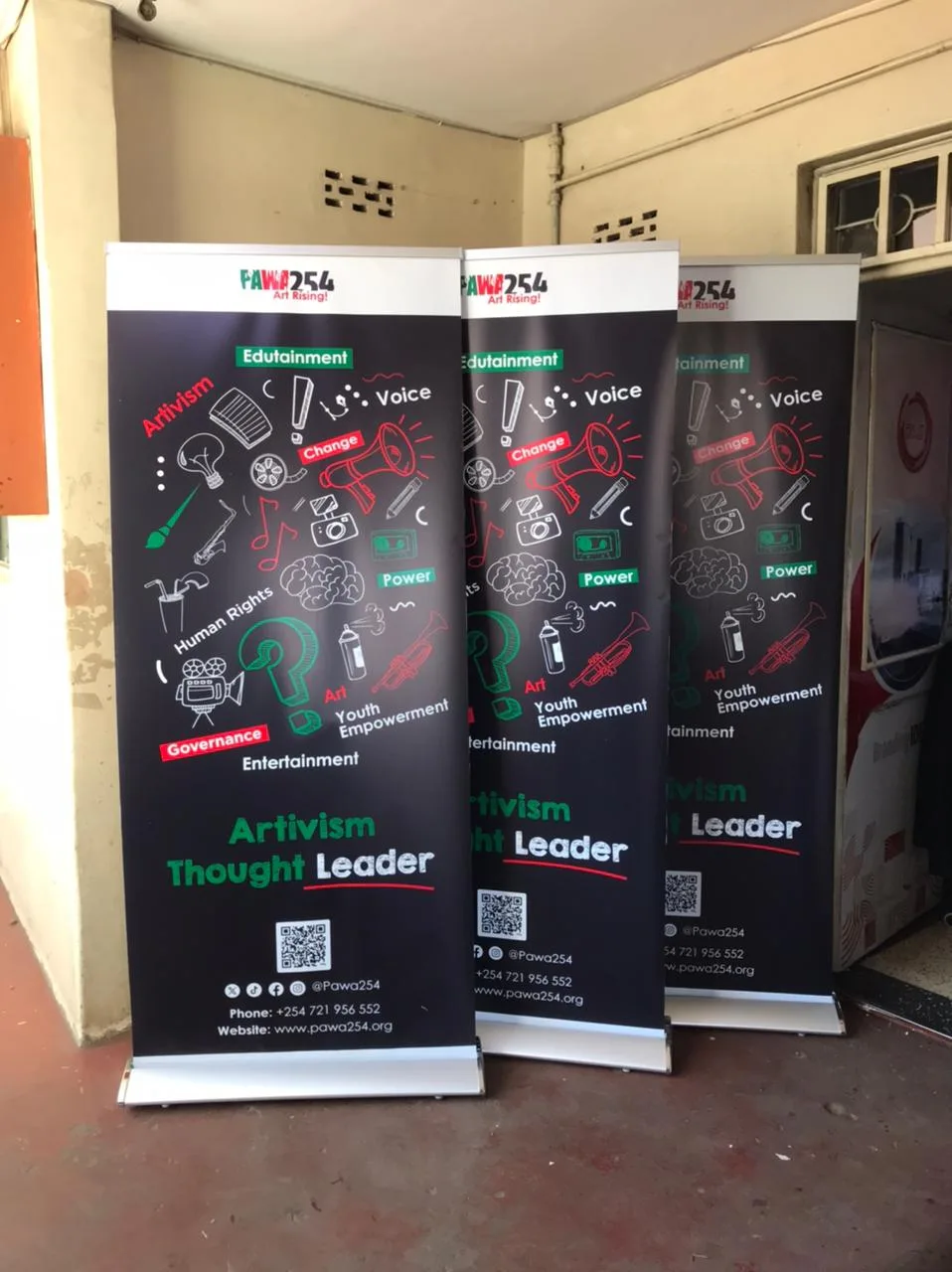 Set of roll-up banners standing at an indoor event, cassette bases visible